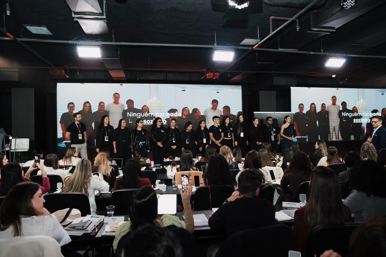 Fundador da FWD com o time no palco de um grande evento de marketing, plateia lotada